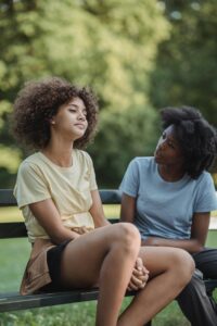 Mother and daughter having a serious talk on a park bench on a sunny day.